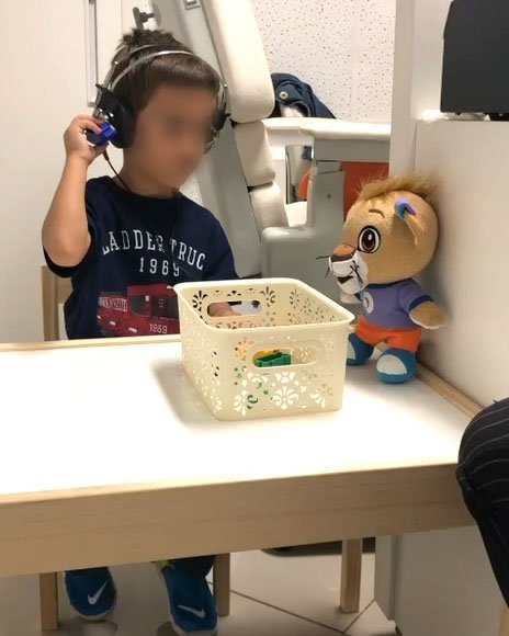 Criança realizando exame de audiometria na Clínica Andreia Lot